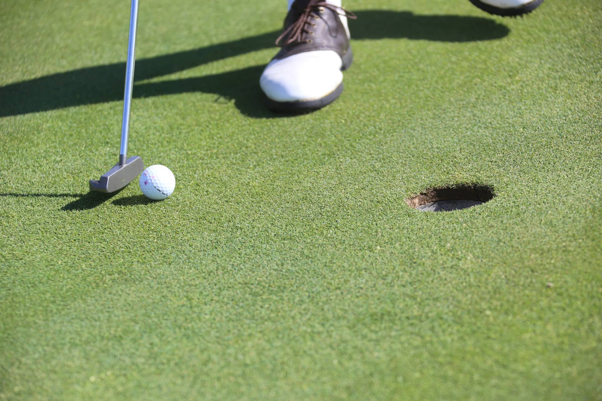 A putt rolling toward the cup on a smooth green